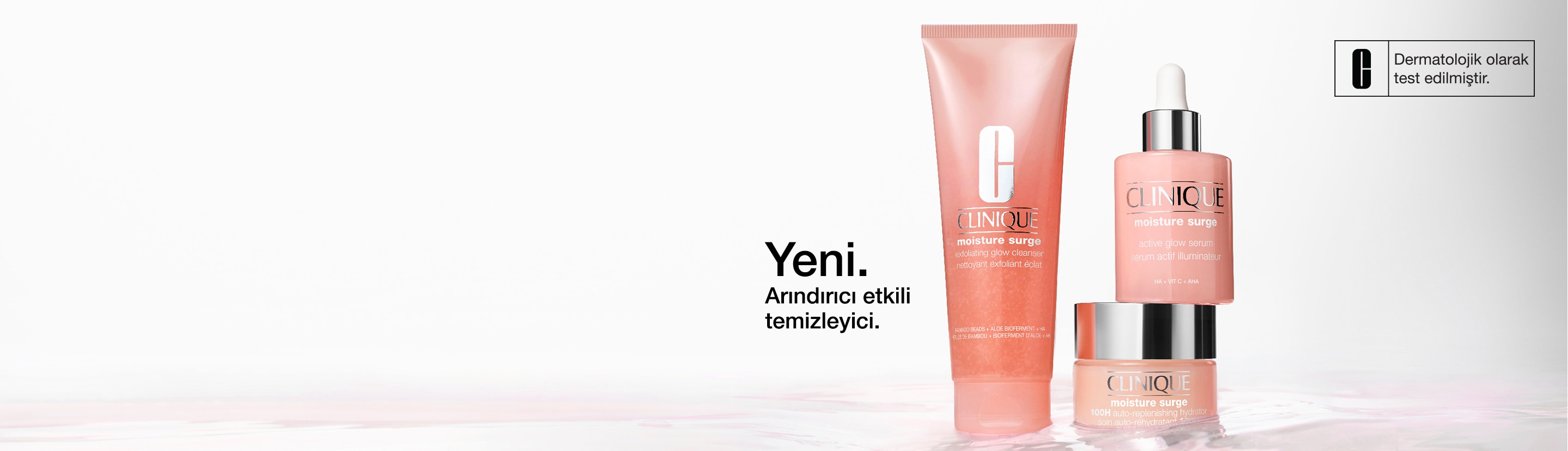 Moisture Surge Serum and 100H Moisturiser stood in a pool of brightly lit, clear water, with hydrating droplets splashing up